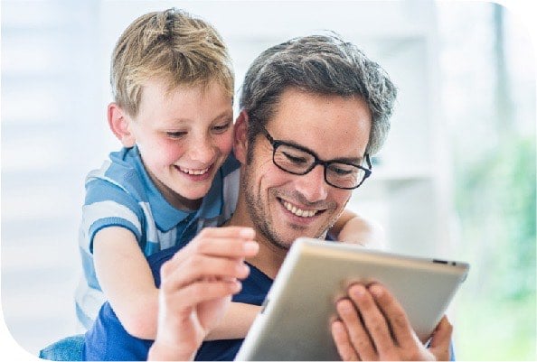 Man using tablet with young child looking over his shoulder